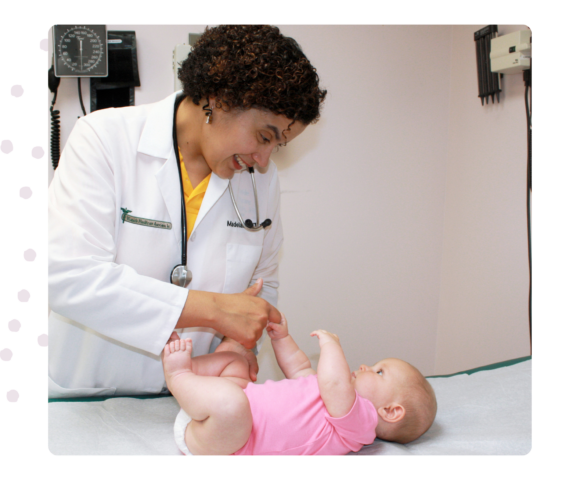 Image of Provider with a baby; baby is laying on exam table.